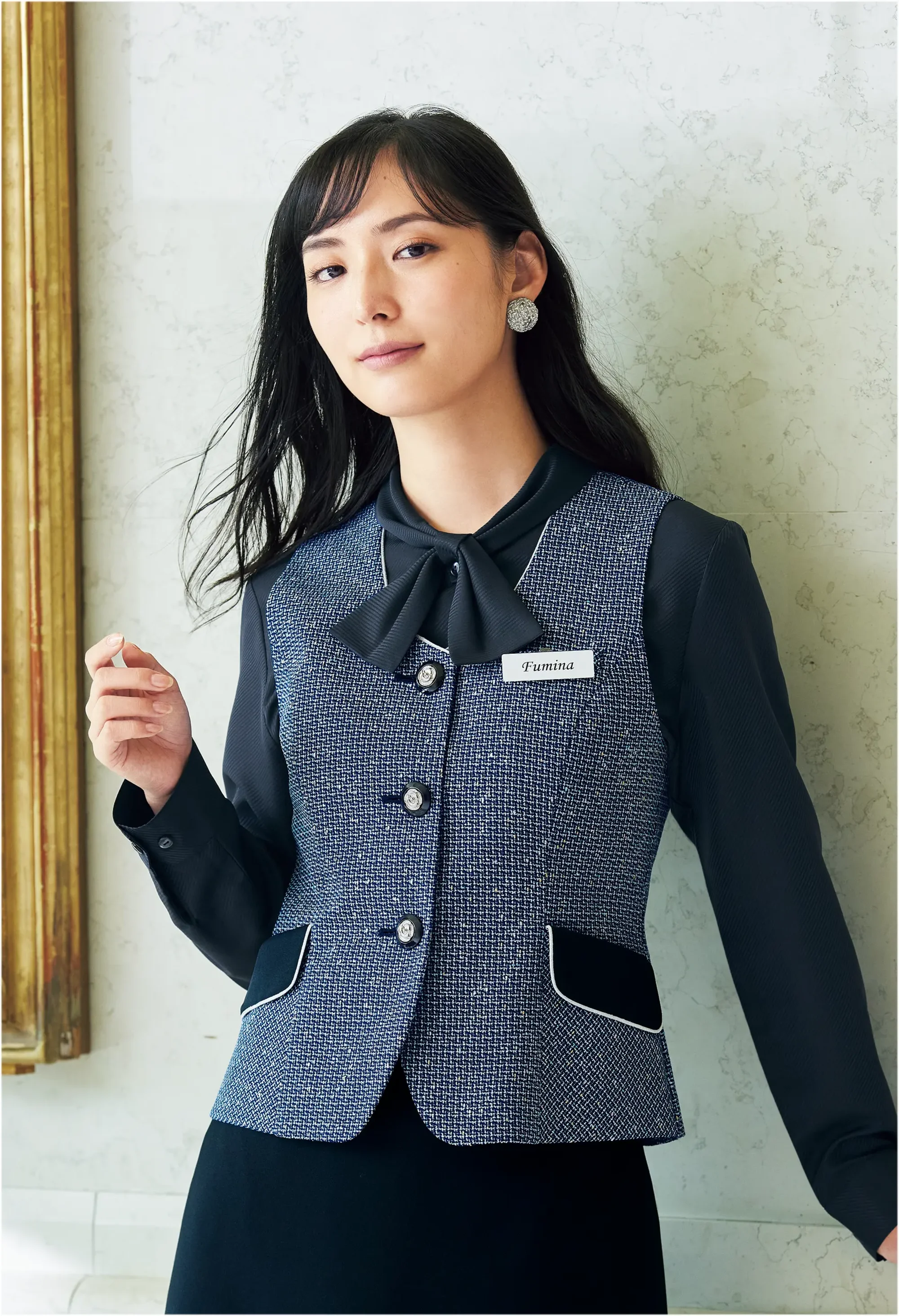 ジョア 12130-1 ベスト 12130-1 ベストen joieの華やぎコンシェルジュ®コレクションから、ネップ糸を織り込んだマカロンツイード素材で仕立てた上品なベストです。ネイビーと白のミニチェックにシルバーラメをちりばめた生地厚5の高品質素材で、フロント業務やアテンド業務での存在感と品格を演出します。ホームクリーニング対応で日常のお手入れも簡単、実用的な名札ポケット付きで接客業務をスマートにサポートします。特徴・ネップ糸を織り込んだツイード素材で上質なラグジュアリー感を演出・ネイビーと白のミニチェック柄にシルバーラメをちりばめた華やかなデザイン・名札ポケット付きで胸ポケットにペンを挿しても邪魔にならない実用設計・ホームクリーニング対応で日常のお手入れが簡単・生地厚5のしっかりとした質感で型崩れしにくい・インフォメーション、アテンド、フロント業務など接客業務に最適・ワンピースやジャケットとのコーディネートで統一感のある空間演出が可能・企業価値を高めるおもてなしの心を表現するデザイン※21～25号は受注生産になります。※受注生産品につきましては、ご注文後のキャンセル、返品及び他の商品との交換、色・サイズ交換が出来ませんのでご注意ください。※受注生産品のお支払い方法は、前払いにて承り、ご入金確認後の手配となります。